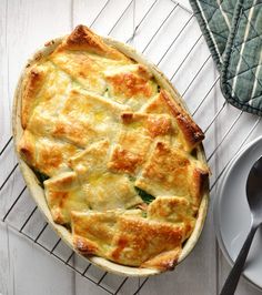 a pie sitting on top of a cooling rack next to a plate with a fork