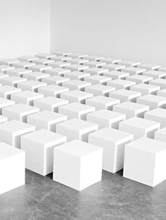 a room filled with lots of white cubes sitting on top of a cement floor