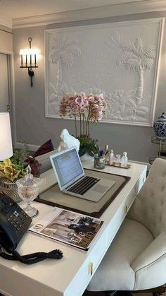 a laptop computer sitting on top of a white desk