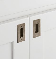 two white cupboards with metal pulls on them