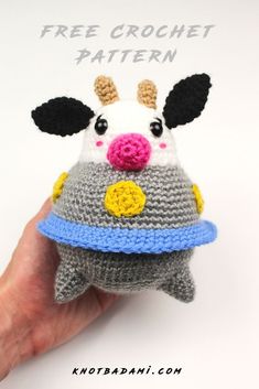 a hand holding a knitted toy with a cow on it