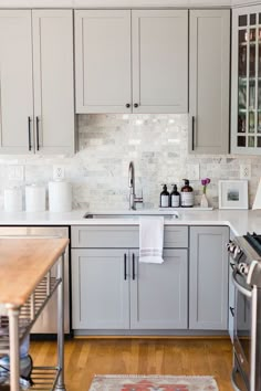 a kitchen with gray cabinets and wood floors