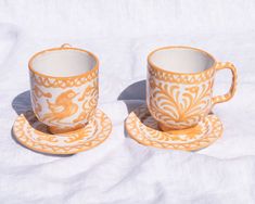 two cups and saucers on a white cloth