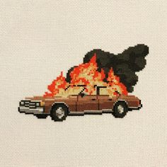 a cross - stitch picture of a car on fire