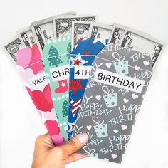 a person holding up a bunch of birthday cards