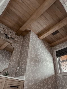 a bathroom with wooden ceiling and wall paper