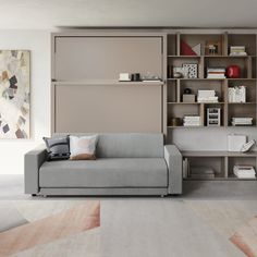 a living room filled with furniture and bookshelves next to a painting on the wall