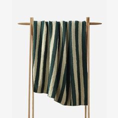 a green and white striped towel hanging on a wooden rack