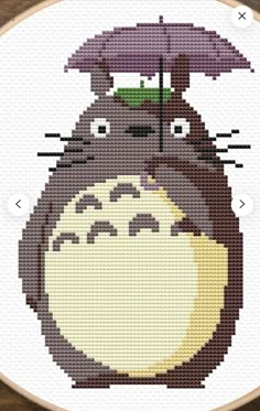 a cross stitch pattern with a totoro and an umbrella on top of it