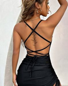 the back of a woman's body wearing a black dress with cross - over straps