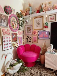 a living room with pink furniture and pictures on the wall