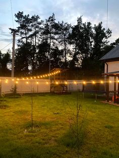 the backyard is lit up with string lights