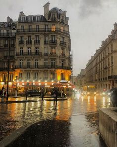 people are walking down the street in the rain