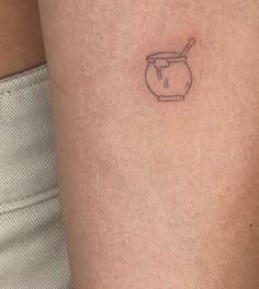 a woman's arm with a small tattoo of a teapot and spoon on it