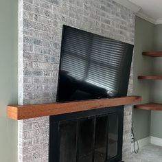 a flat screen tv mounted on top of a brick fireplace