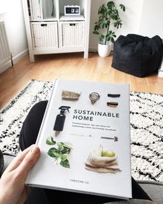 a person sitting on the floor holding up a book