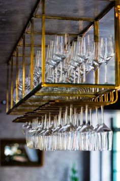 several wine glasses are hanging from the ceiling