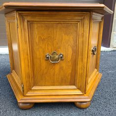 an old wooden cabinet with brass hardware on the front and side doors is sitting outside