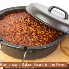 a pot filled with baked beans sitting on top of a wooden table