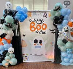 balloons and decorations are displayed in front of a sign that says our little boo is blue