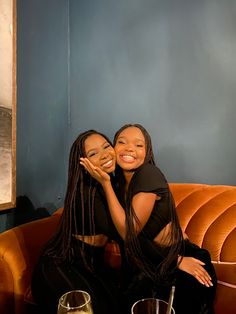 two women sitting on a couch hugging each other