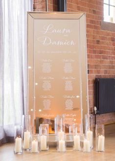 candles are lined up in front of a sign with the names of each wedding ceremony