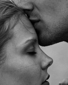 a man and woman kissing each other with their noses close together