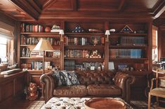 a living room filled with furniture and bookshelves covered in lots of shelves next to a window