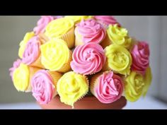 cupcakes with pink and yellow frosting in a vase