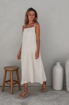 A woman with blonde hair in a striped dress, looking down placed in a minimalistic indoor setting. Modest Summer Style, Summer Fits 2024, Italian Summer Dresses, What To Wear In Florida, Dress Like An Italian Woman, Casual Church Outfits Summer, Cute Casual Summer Outfits, Linen Dress Outfit, Summer Dress Linen