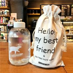 a bottle of water sitting next to a bag filled with liquid on top of a wooden table