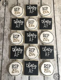 twelve decorated cookies with black and white icing are arranged in the shape of letters