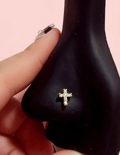 a person holding a small black object with a cross on it