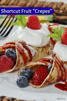 pancakes with fruit and whipped cream on them are sitting on a plate next to a fork