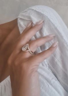 a woman's hand with a wedding ring on her finger, wrapped in a white towel