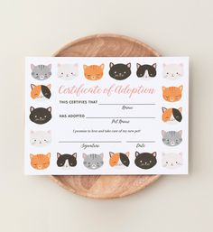 a certificate with cats on it sitting on top of a wooden plate