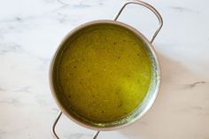 a pot filled with green liquid sitting on top of a counter