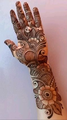 a woman's hand with henna tattoos on it