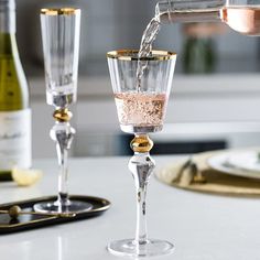 champagne being poured into two wine glasses