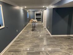 an empty room with blue walls and tile flooring in the center is seen here