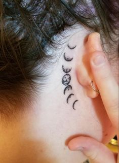 a woman's behind the ear tattoo with phases