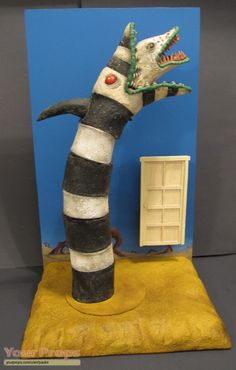 a cat in the hat statue on display with a blue wall and yellow flooring