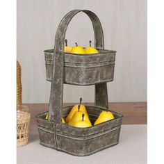 three tiered metal fruit basket with apples and bananas in the bottom, sitting on a table