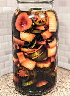 a jar filled with sliced up vegetables on top of a counter