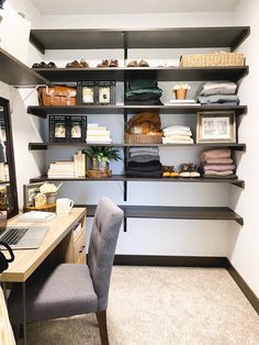 a desk with a laptop computer sitting on top of it next to shelves filled with folded clothes