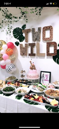 a table topped with lots of food next to a sign that says hello wild on it