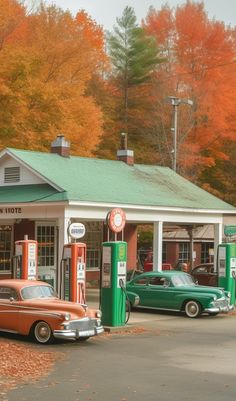 an old car is parked in front of a gas station with autumn leaves on the trees