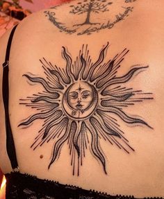 a woman with a sun tattoo on her back