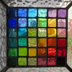 a multicolored stained glass window in the shape of a square