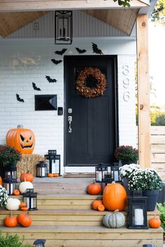 the front porch is decorated for halloween with pumpkins, lanterns and other decorations on it